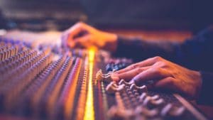 male producer, sound engineer hands working on audio mixing cons